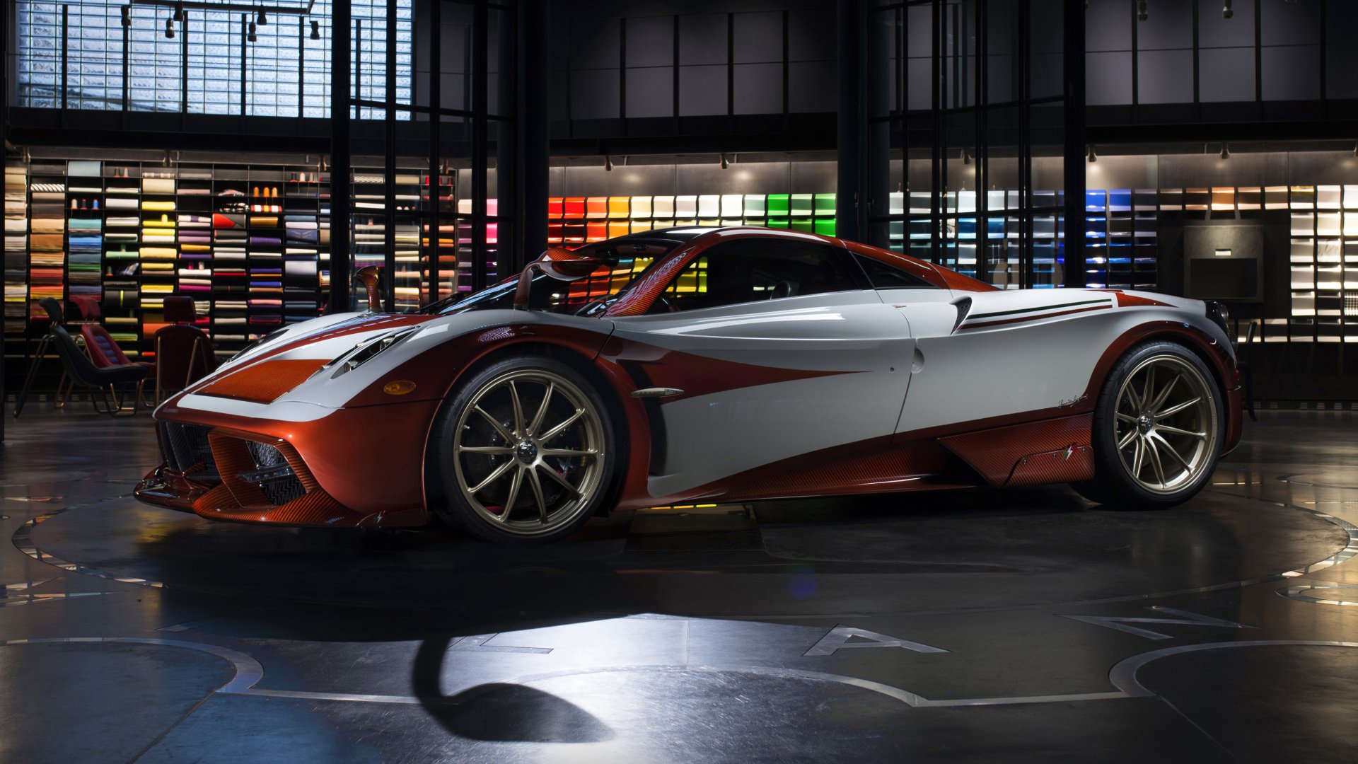 Sleek Pagani Huayra supercar showcased indoors with dynamic lighting, presented as a 4K Ultra HD PC desktop wallpaper and background.