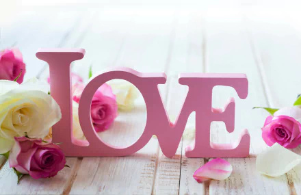 A 4K Ultra HD desktop wallpaper featuring pink LOVE letters surrounded by white and pink rose petals on a wooden surface, creating an artistic and romantic scene.