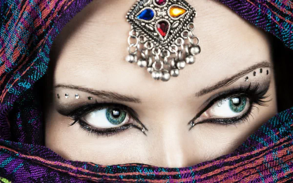 HD desktop wallpaper: close-up of a woman’s blue eyes, a jeweled bindi and rhinestones above the brows, partially veiled by a colorful scarf.