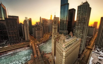 High-definition desktop wallpaper showcasing a stunning view of Chicago's skyline at sunset, with the city's iconic architecture and river prominently featured.