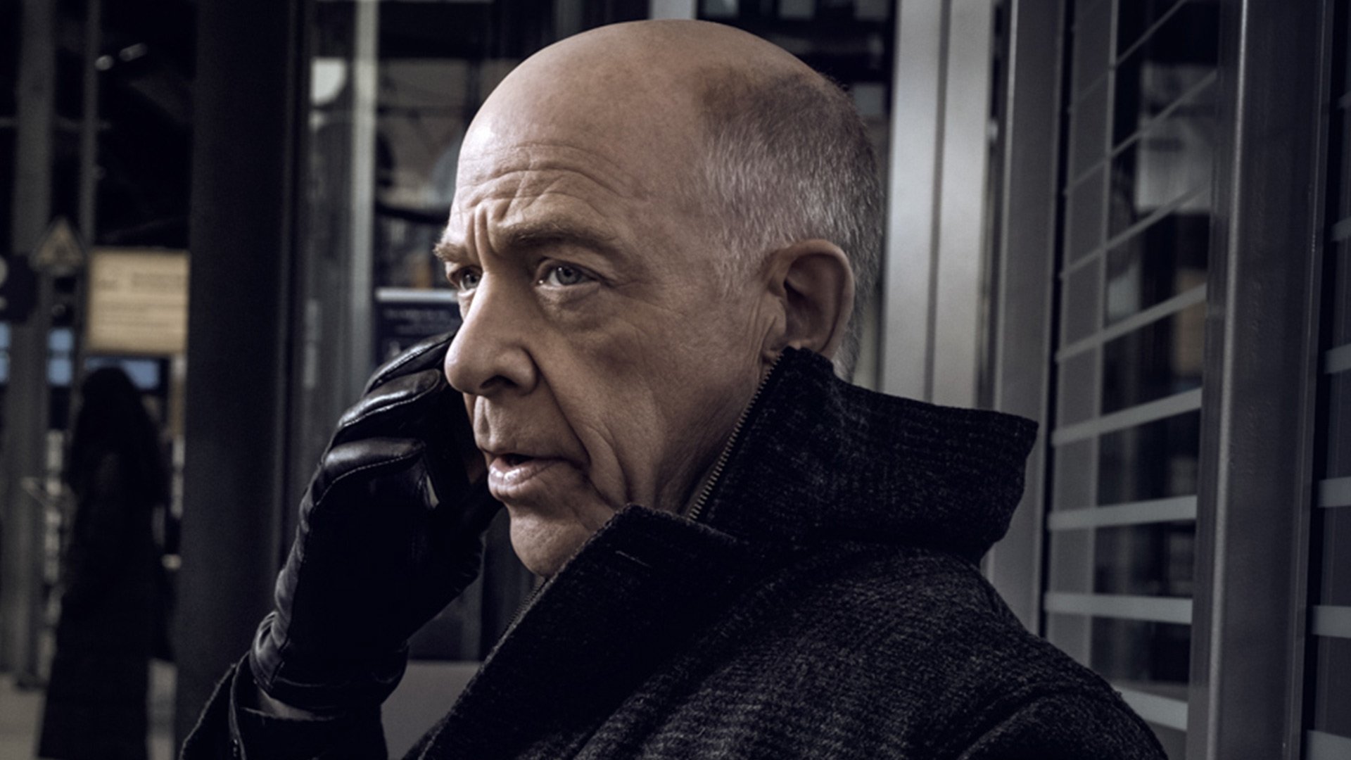 HD desktop wallpaper featuring a character from the series Counterpart, portrayed by an actor on the phone with a serious expression.