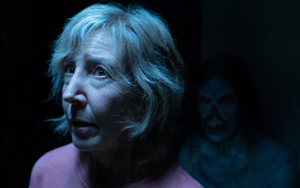 HD desktop wallpaper of a scene from Insidious: The Last Key with a fearful woman and a ghostly figure in the background.