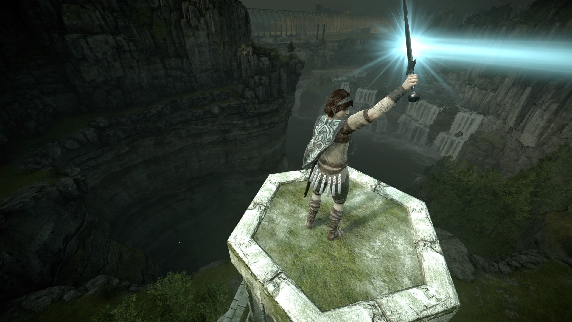 4K Ultra HD PC wallpaper of Shadow of the Colossus, featuring the protagonist holding a glowing sword atop a stone pillar overlooking a vast canyon landscape.
