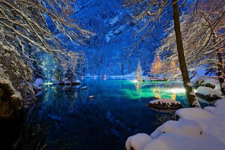 HD wallpaper of a serene, snowy night scene at a lake in Switzerland, surrounded by trees and illuminated by lights. The tranquil water and winter landscape create a peaceful nature setting.