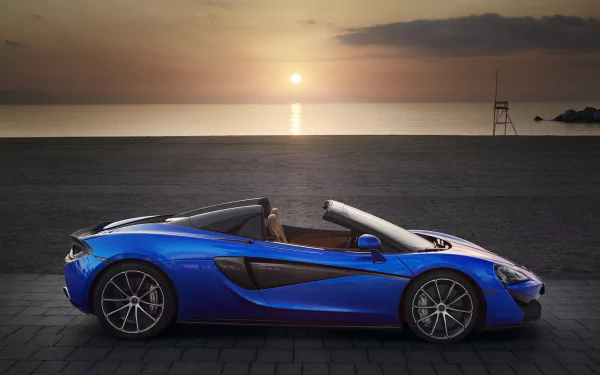 Blue McLaren 570S Spider supercar parked by the sea at sunset — 5K Ultra HD PC desktop wallpaper/background showcasing the convertible vehicle's profile.