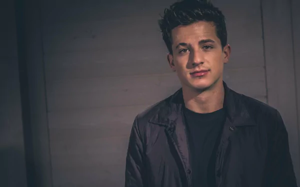 HD desktop wallpaper featuring a portrait of a man with a subdued expression, wearing a dark jacket, against a textured background.