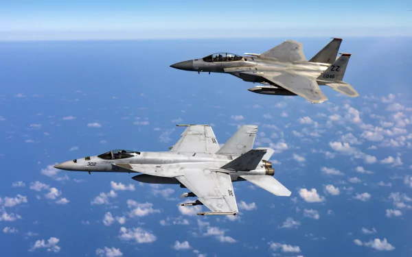 HD desktop wallpaper featuring a Boeing F/A-18E/F Super Hornet and a McDonnell Douglas F-15 Eagle jet fighter flying over a vast sky, showcasing the sleek design of military warplanes.