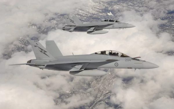 Two McDonnell Douglas CF-18 Hornet military jet fighters fly above clouds, captured in high-definition as a striking warplane desktop wallpaper.