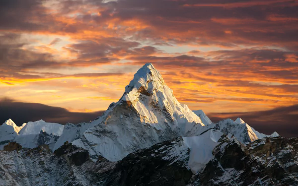 HD wallpaper of a Himalayan mountain peak at sunset, showcasing a serene natural scene with a vibrant sky in the background.
