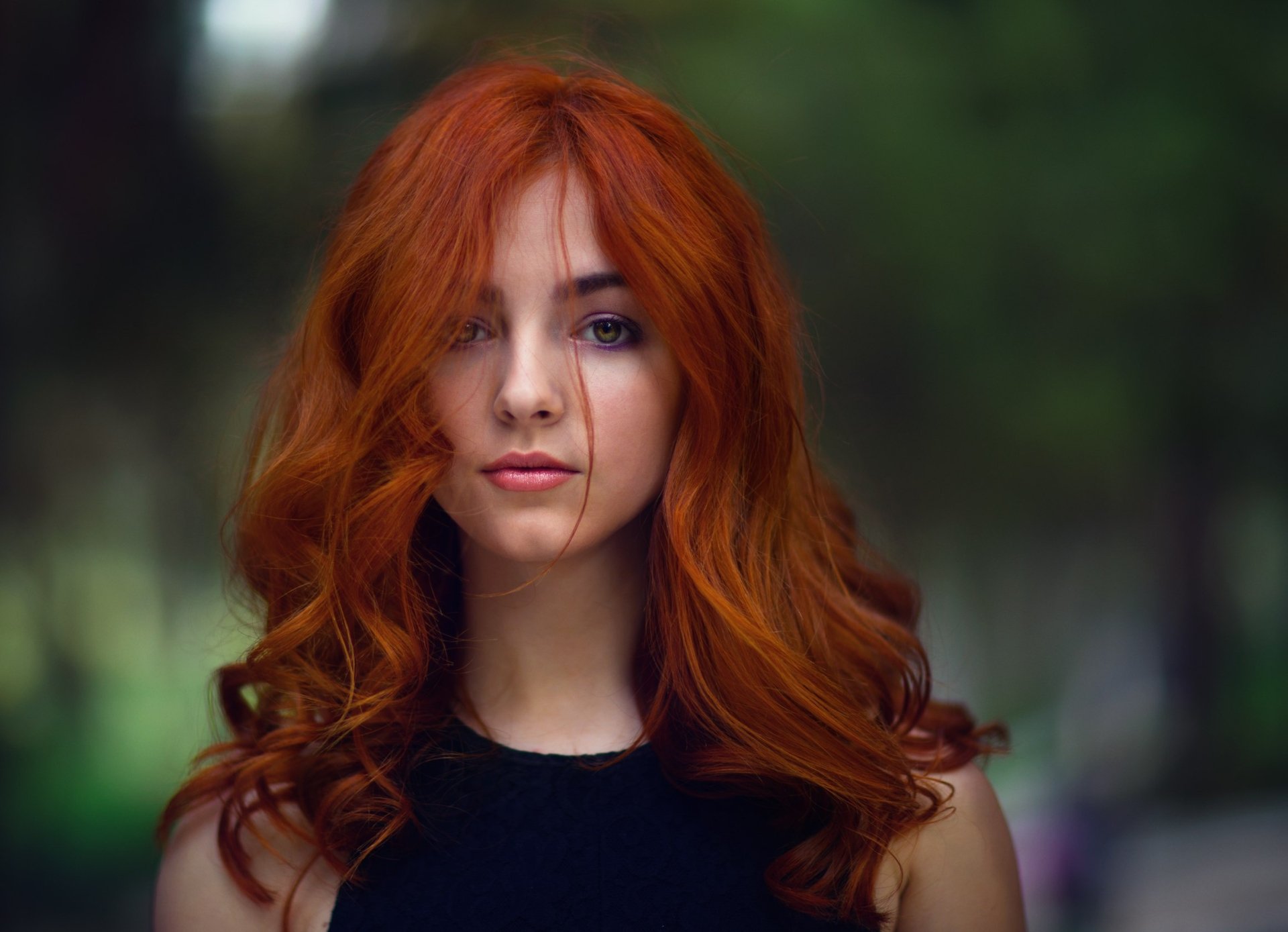 HD desktop wallpaper featuring a redhead woman model with striking blue eyes, captured in sharp focus against a softly blurred depth of field background.
