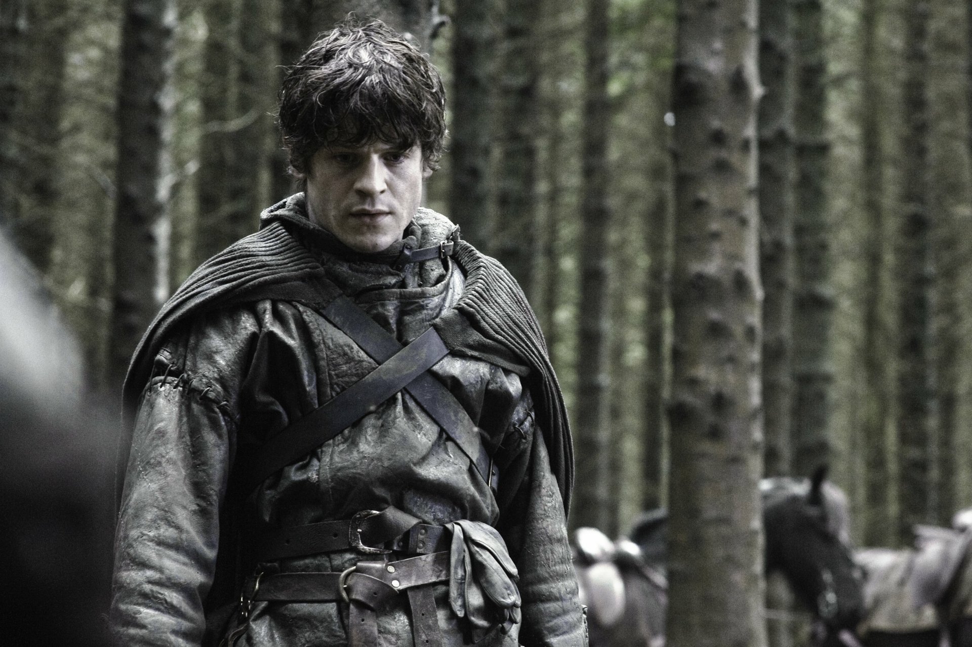 Ramsay Bolton (Game of Thrones) stares grimly in a dim pine forest, cloaked and battle-worn — 4K Ultra HD PC desktop wallpaper/background.