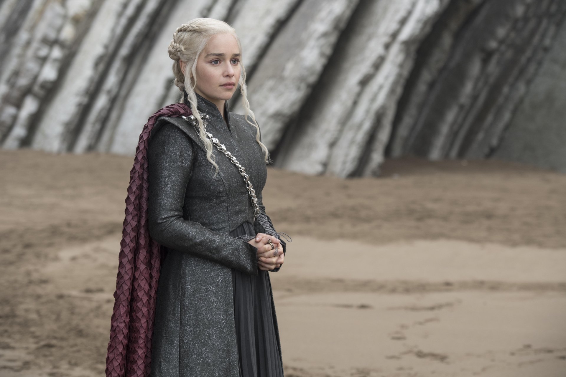 4K Ultra HD wallpaper featuring Emilia Clarke as Daenerys Targaryen from the TV show Game of Thrones, standing with a braided hairstyle and dark outfit.