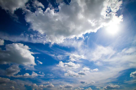 5K Ultra HD PC desktop wallpaper: expansive blue sky with dramatic white clouds and sunbeams, a serene nature cloudscape.