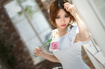 HD desktop wallpaper of an Asian brunette model with short hair and brown eyes, holding a pink rose while looking directly at the camera.