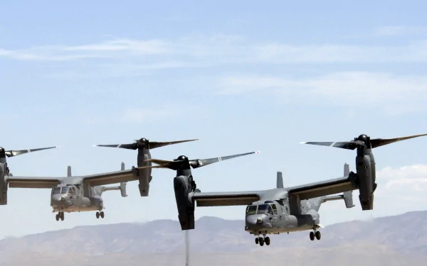 HD PC desktop wallpaper featuring military Bell Boeing V-22 Osprey aircraft flying in formation against a clear sky and mountainous background.