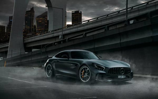 A sleek green Mercedes-AMG GT supercar parked under an urban overpass, captured in 4K Ultra HD for a dramatic PC desktop wallpaper background.