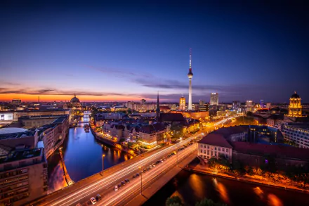 Nighttime cityscape of Berlin, Germany, featuring illuminated buildings and bridges over the river, captured in stunning 4K Ultra HD for a PC desktop background.