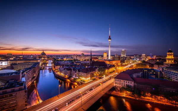 Nighttime cityscape of Berlin, Germany, featuring illuminated buildings and bridges over the river, captured in stunning 4K Ultra HD for a PC desktop background.