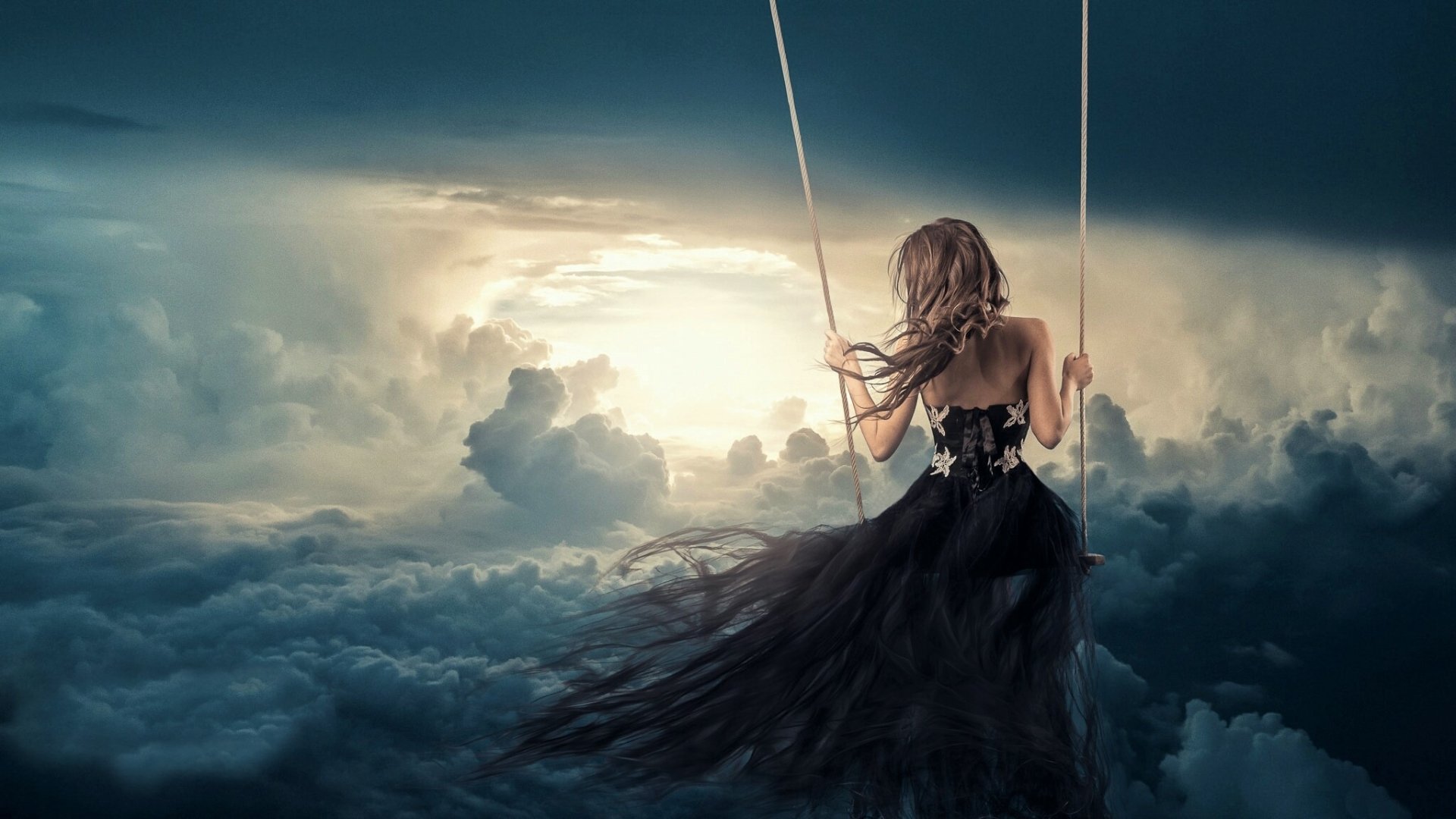 A woman in a flowing black dress swings high above the clouds against a dramatic sky, creating a fantasy-themed HD PC desktop wallpaper and background.