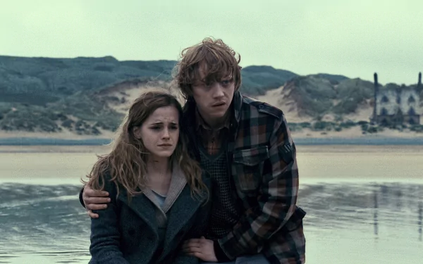 Hermione Granger and Ron Weasley from Harry Potter and the Deathly Hallows: Part 1 embrace on a windswept beach — HD PC desktop wallpaper and background.