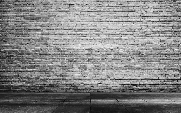 4K Ultra HD PC desktop wallpaper: grayscale photo of a man-made brick wall and concrete pavement, gritty urban texture.