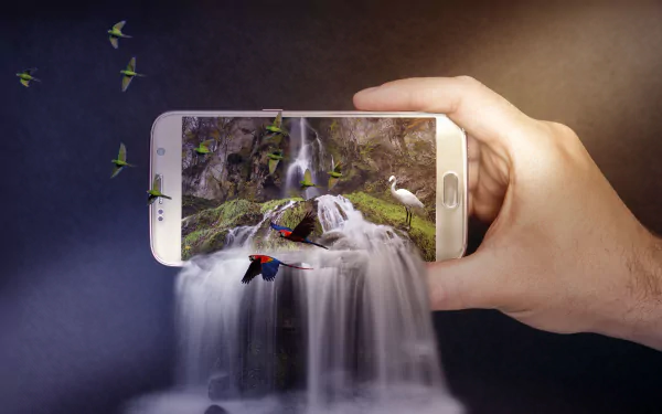 A hand holds a smartphone displaying a vibrant waterfall scene with birds flying out, blending digital photography and manipulation in 4K Ultra HD.