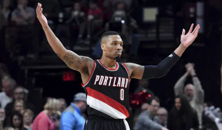 HD desktop wallpaper featuring basketball player Damian Lillard in a Portland jersey with arms outstretched during a game.