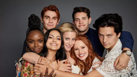 HD desktop wallpaper featuring the cast of the TV show 'Riverdale,' with the characters embracing and smiling against a plain backdrop.
