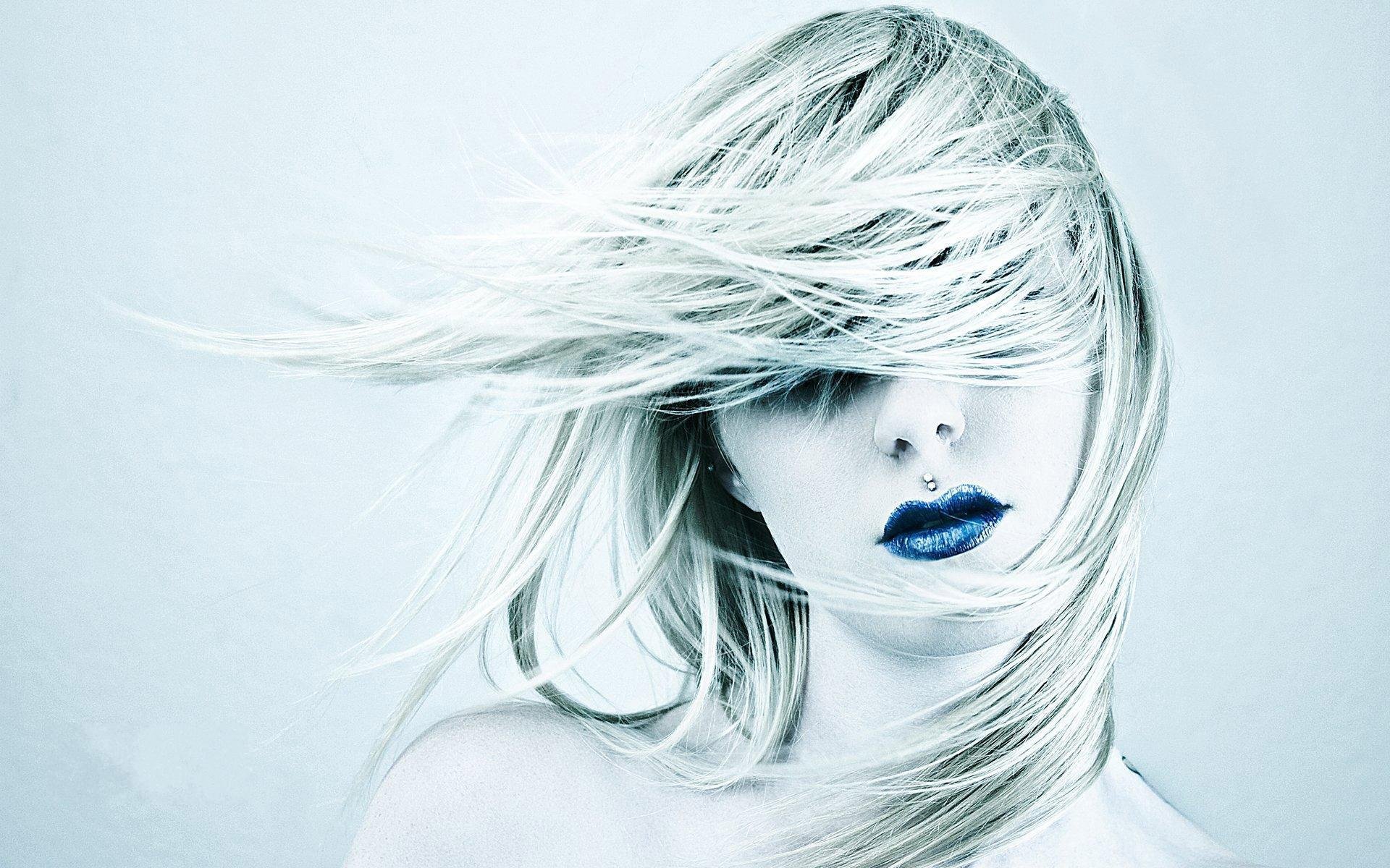 A woman with flowing hair and striking blue lips is captured in this artistic HD desktop wallpaper, exuding a sense of movement and ethereal beauty against a soft background.