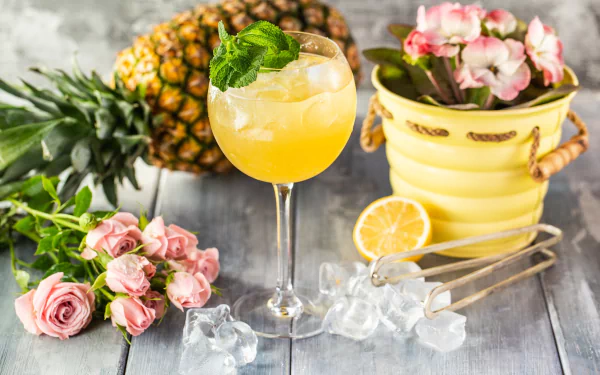 HD desktop wallpaper featuring a refreshing cocktail with ice cubes, a pineapple, pink roses, and a yellow pot with flowers in a vibrant still life composition.