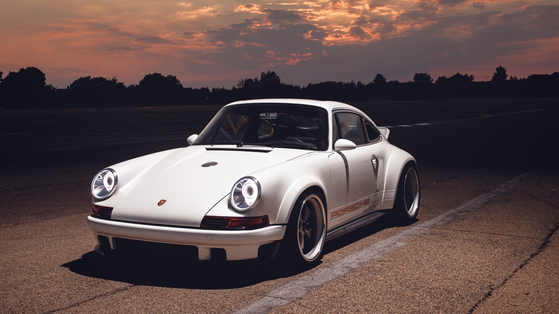 White Porsche 911 sports car parked on an empty road at sunset, 2K Quad HD PC desktop wallpaper and background.