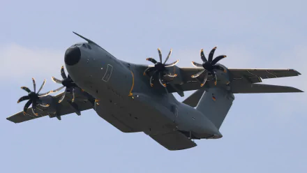 Airbus A400M military transport aircraft in flight, four turboprops spinning against a pale sky — 4K Ultra HD PC desktop wallpaper background.
