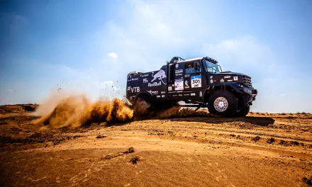 Kamaz Red Bull rally truck kicking up sand across a desert, high-speed rallying action and sports intensity — 4K Ultra HD PC desktop wallpaper background.