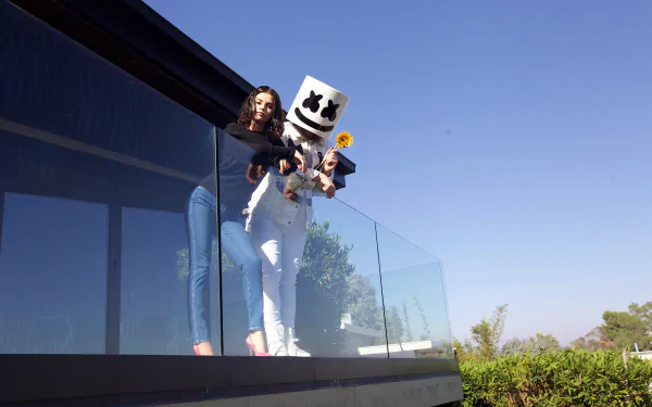 Selena Gomez and DJ Marshmello stand on a balcony under a clear sky, captured in a vibrant 4K Ultra HD music-themed desktop wallpaper.
