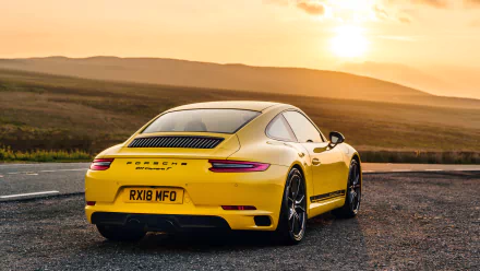 Yellow Porsche 911 Carrera T rear three-quarter view on a road at sunset, 4K Ultra HD PC desktop wallpaper.