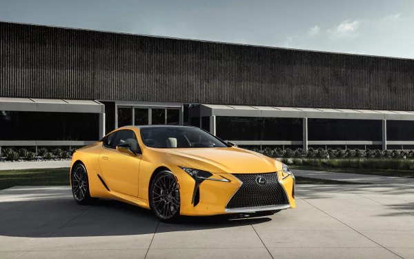 Yellow Lexus LC 500 Inspiration Concept grand tourer parked in front of a modern building, showcased as an HD PC desktop wallpaper and background.