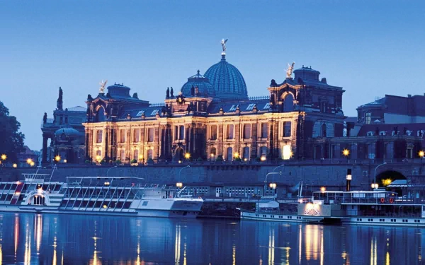HD desktop wallpaper of a beautifully illuminated man-made palace monument in Budapest, reflected on the calm river at dusk.