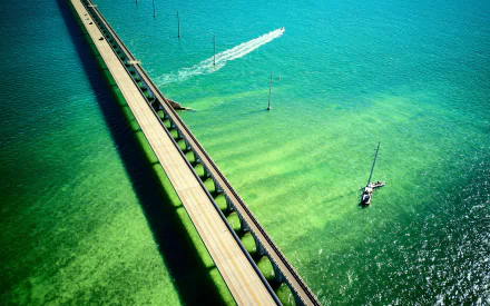 Aerial view of the man-made Seven Mile Bridge stretching over clear turquoise waters, with boats navigating nearby in this 4K Ultra HD desktop wallpaper.