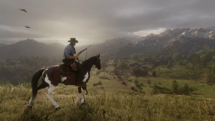 Arthur Morgan from Red Dead Redemption 2 rides a horse in an expansive, scenic countryside in this HD desktop wallpaper and background. The setting includes mountains and birds flying in a cloudy sky.