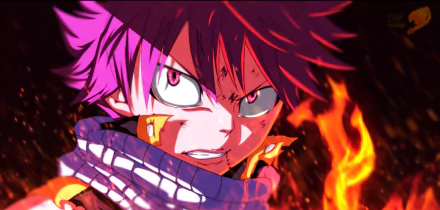 HD PC desktop wallpaper of Natsu Dragneel from Fairy Tail — intense close-up of him grinning with flaming aura, glowing eyes and scarf against a blazing fire background.