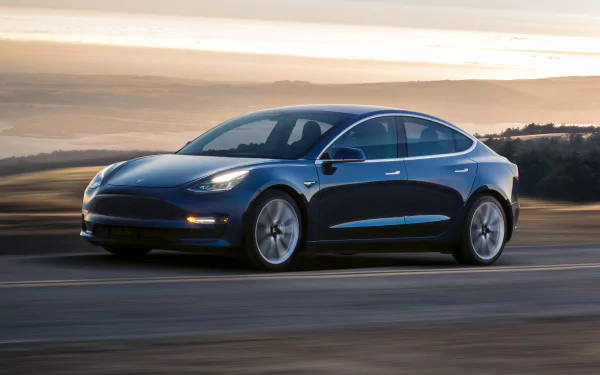 A Tesla Model 3 car in motion, serving as an HD desktop wallpaper and background.