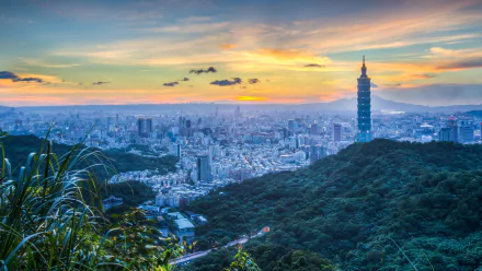 HD desktop wallpaper showcasing Taipei's cityscape featuring skyscrapers, including the iconic Taipei 101, against a sunset sky with lush greenery in the foreground.