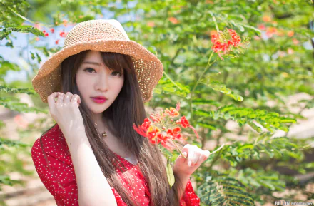 HD desktop wallpaper: brunette model with long hair, wearing a straw hat and red lipstick, holding red blossoms in a sunlit garden.