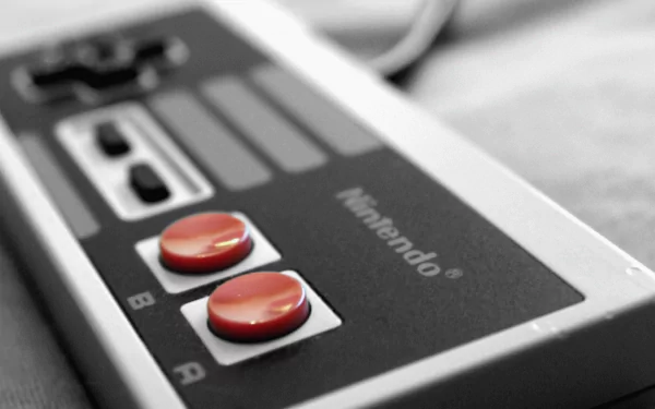 Close-up of a classic Nintendo Entertainment System controller, highlighting the iconic red buttons, presented as a HD PC desktop wallpaper and background.