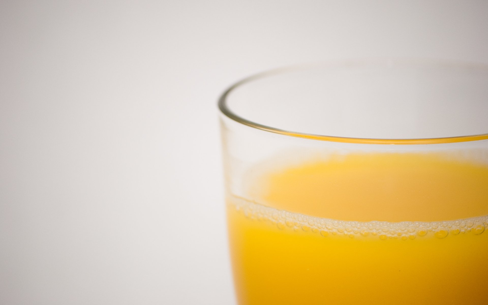 Close-up of a glass filled with bright orange juice, captured in crisp 4K Ultra HD quality for a vibrant PC desktop wallpaper and background.