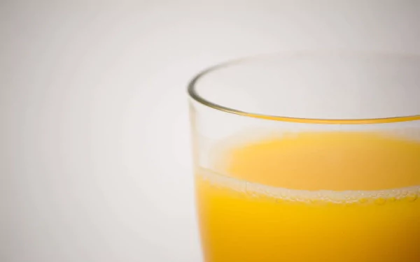 Close-up of a glass filled with bright orange juice, captured in crisp 4K Ultra HD quality for a vibrant PC desktop wallpaper and background.