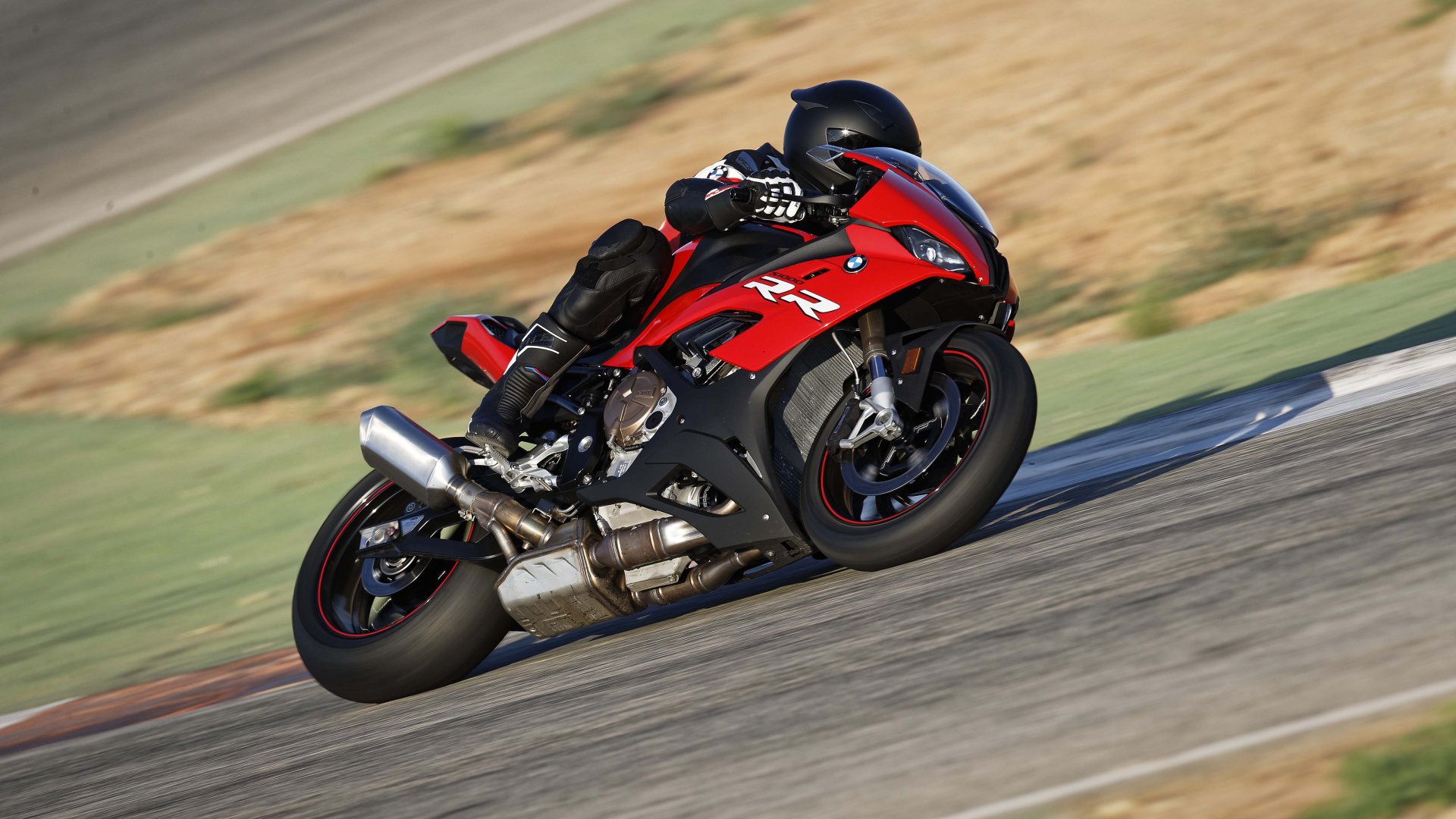 Red BMW S1000 sportbike vehicle leaned into a corner on a racetrack, captured as a 5K Ultra HD PC desktop wallpaper background.