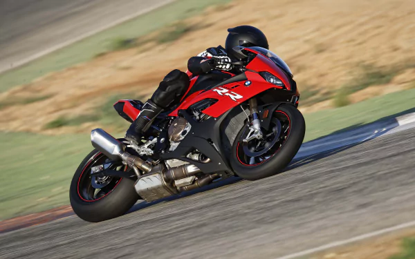Red BMW S1000 sportbike vehicle leaned into a corner on a racetrack, captured as a 5K Ultra HD PC desktop wallpaper background.