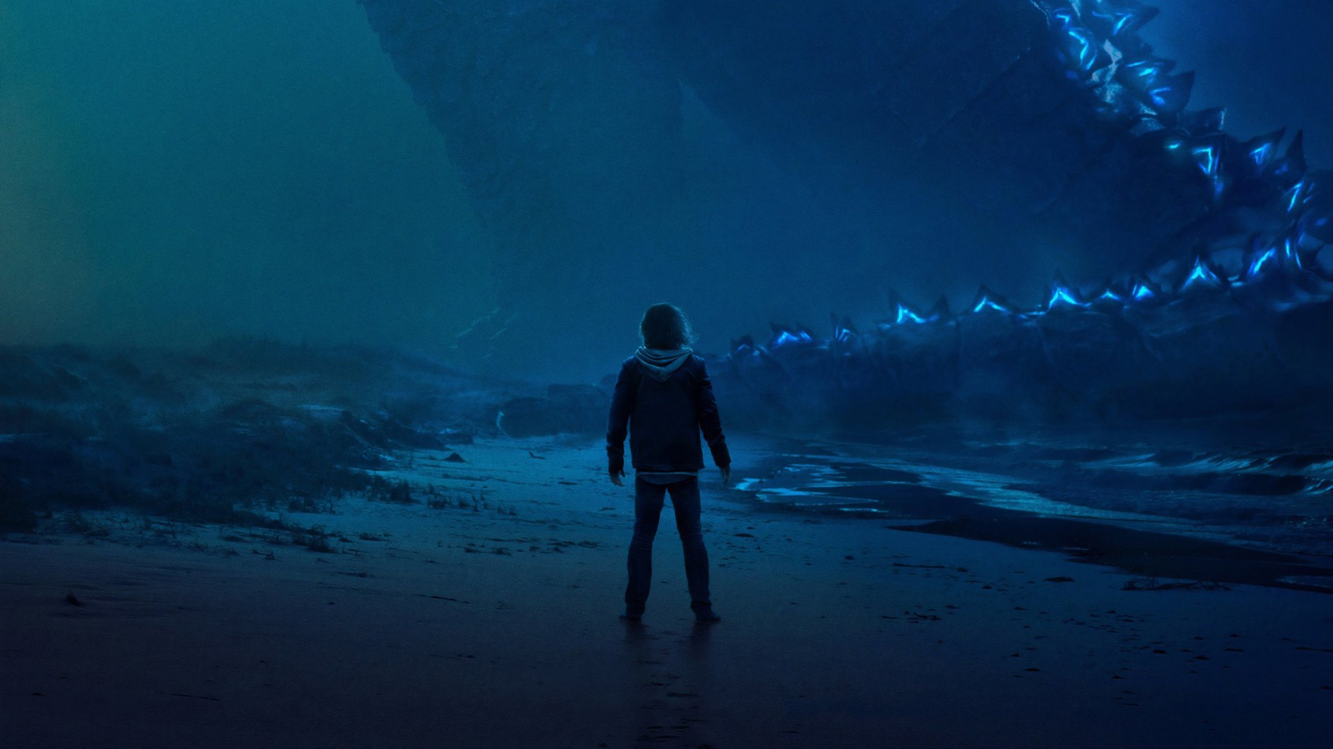 4K Ultra HD PC desktop wallpaper featuring a scene from the movie Godzilla: King of the Monsters, showing a person standing before Godzilla's glowing dorsal fins.