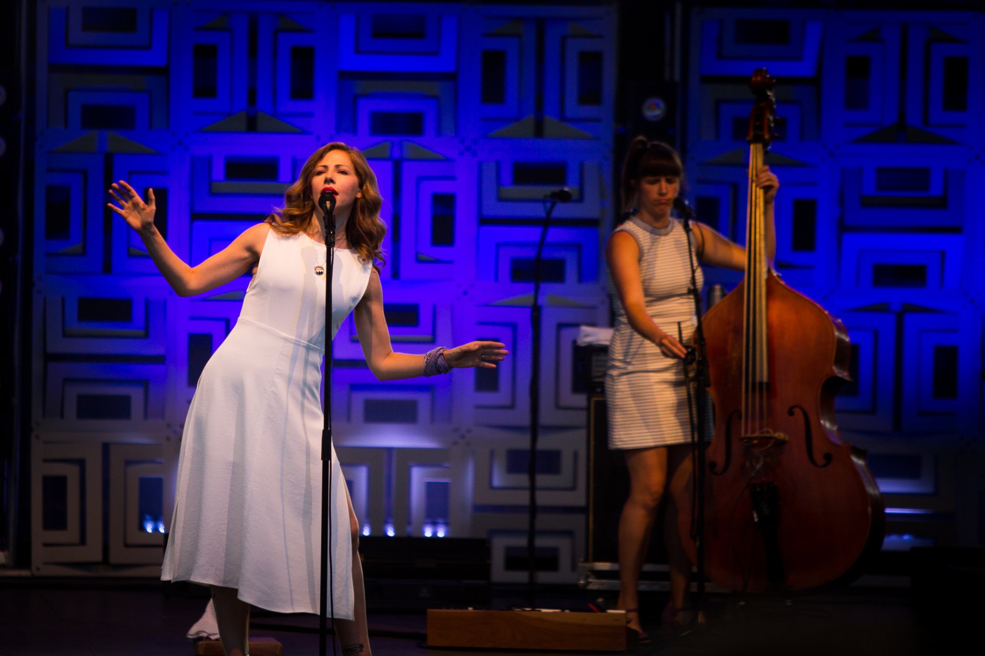 HD desktop wallpaper featuring two members of Lake Street Dive performing live on stage.